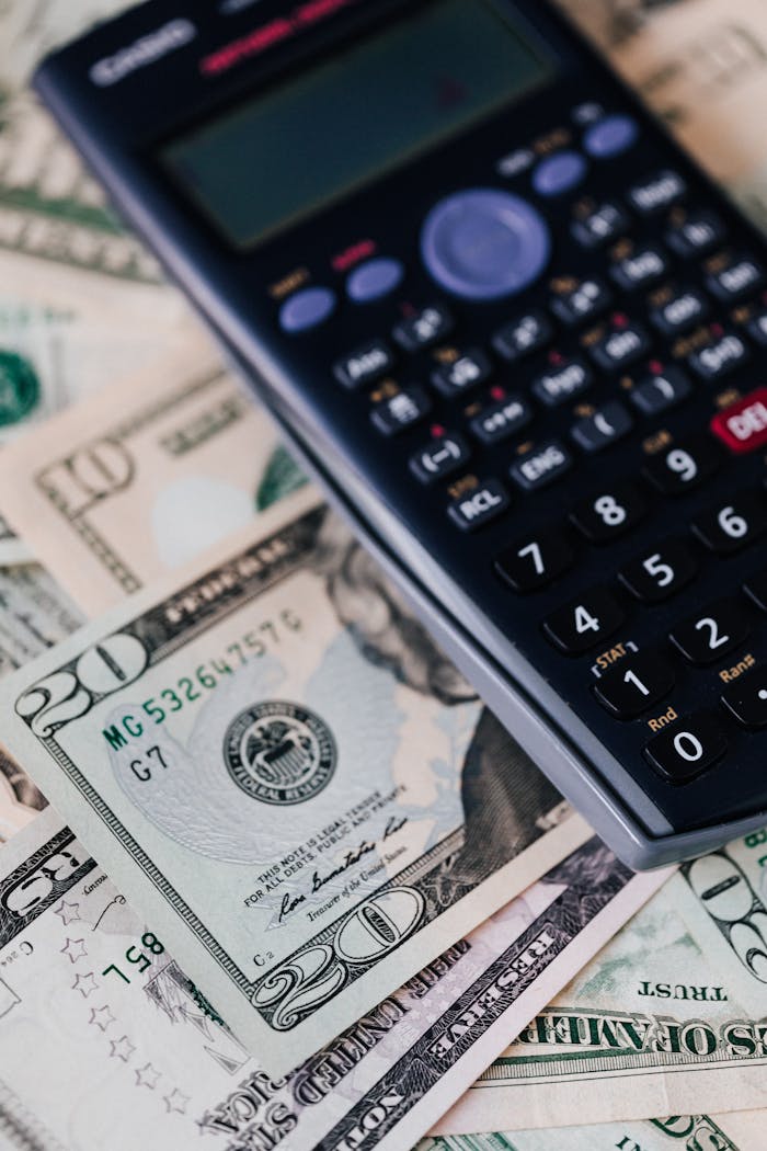 who-we-are From above of calculator placed on paper banknotes of American dollars on table