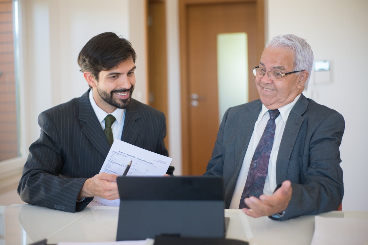 why-choose-us Two businessmen discussing a real estate deal in a modern office setting.
